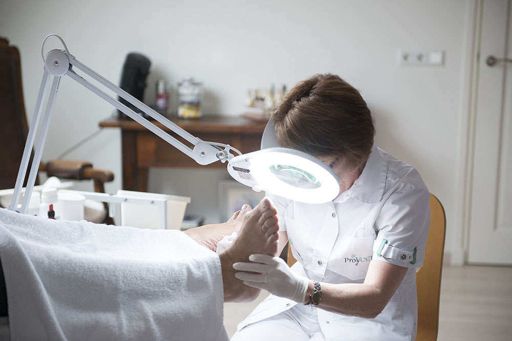 A doctor is examining the injuired foot