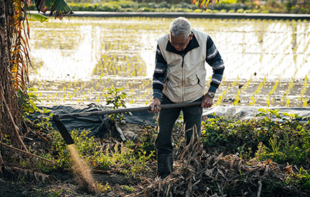 A farmer in rubber hunting boots is farming