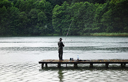 a man is fishing at the lake