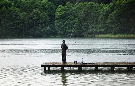 a man is fishing at the lake