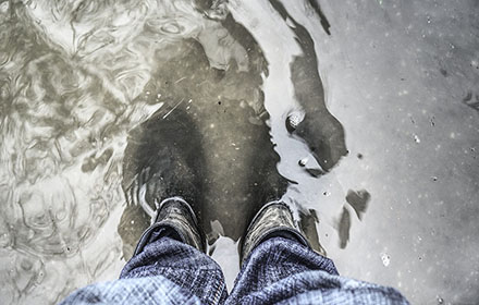 A pair of rubber rain boots in water