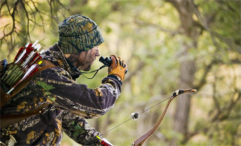 hunter is using hunting binoculars
