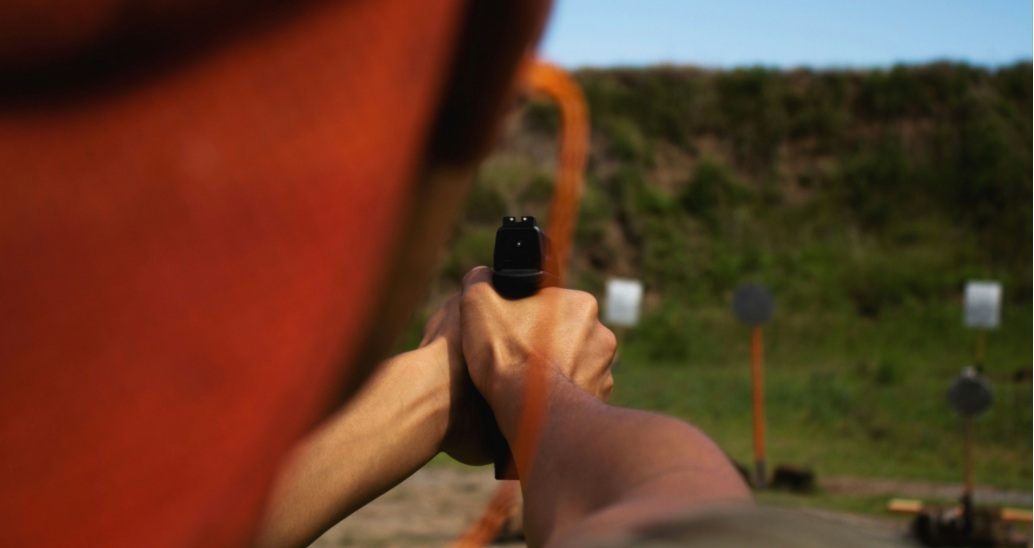 a man is shooting in the wild with a 9mm handgun