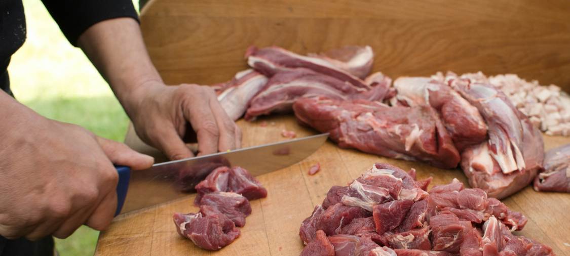 a man is cutting wild pig meat