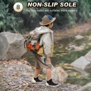 a boy is walking near a small stream, wearing Kalkal childrens black ankle boots