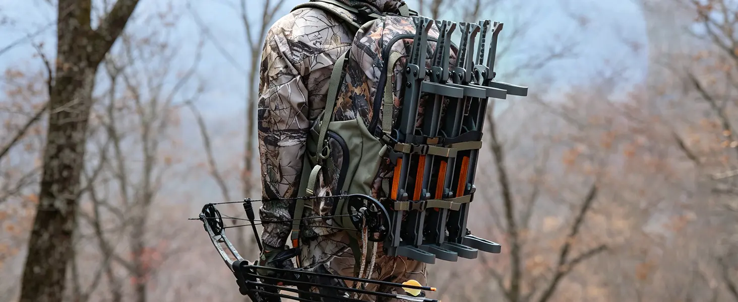 Hunter carrying folded climbing sticks with a backpack while walking through the woods