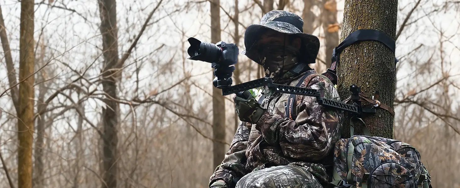 Hunter filming a hunt with a tree stand camera arm mounted to the tree