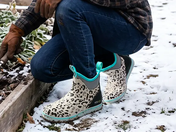 Woman wearing warm rain boots while gardening in winter
